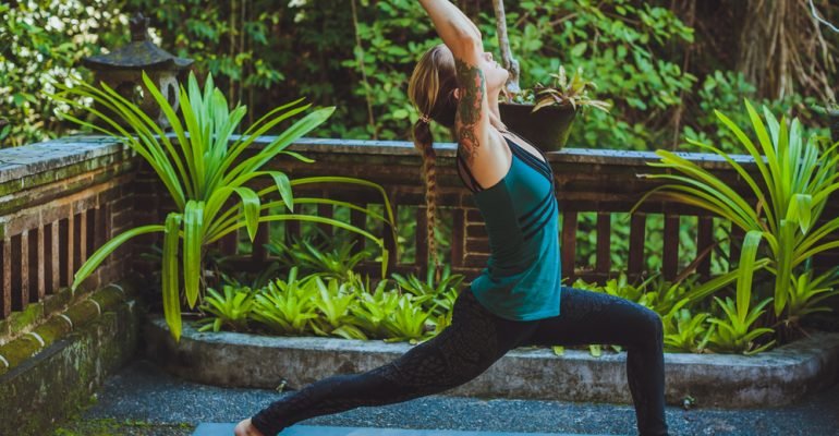 young woman doing yoga outside in natural environment